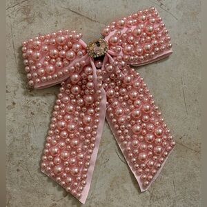 Pink pearl bow hair clip with beaded detail and elegant oversized design